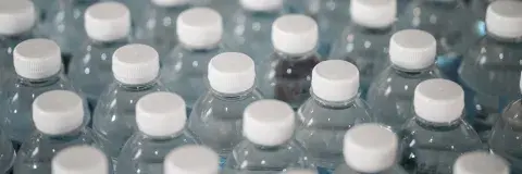 recyclable plastic bottles with white caps arranged in rows