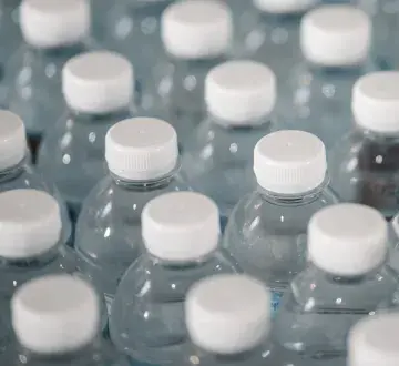 recyclable plastic bottles with white caps arranged in rows