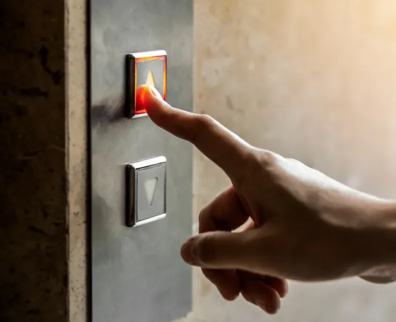 Hand reaching for an elevator button