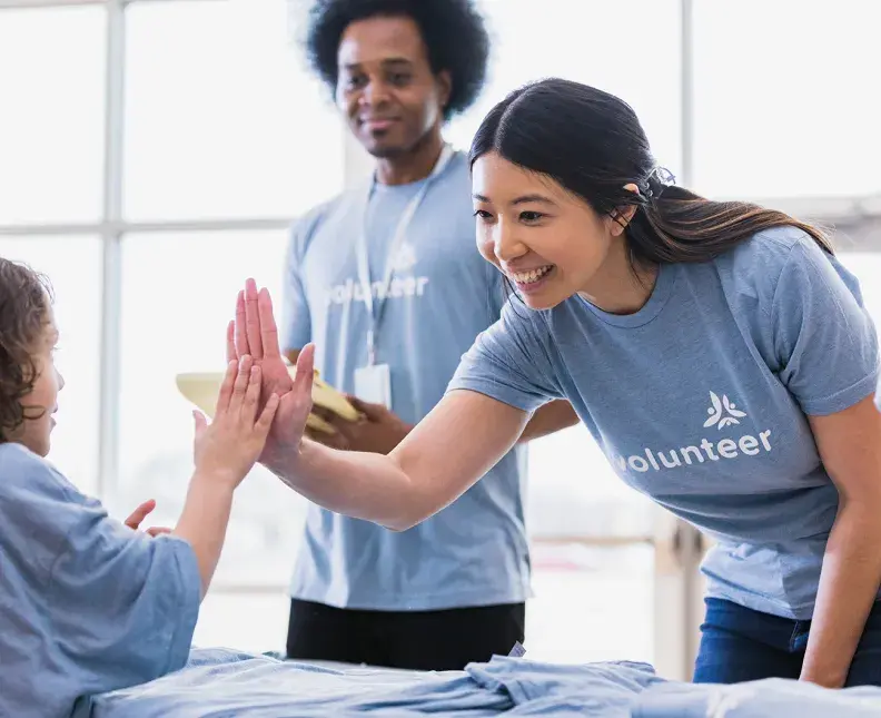 A volunteer and a child high-fiving each other